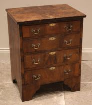 A burr walnut bachelors chest of drawers, early 20th century, the book veneered top over an