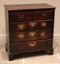 A George III oak chest of drawers, formed with an arrangement of two short and three graduated