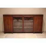 A 19th century inverted breakfront mahogany bookcase, the nulled frieze with a