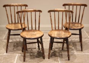 A matched set of four Victorian beech wood kitchen chairs, each with a comb back over a circular