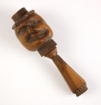 A treen novelty nut cracker, late 19th/early 20th century, the front carved with a face, geometric