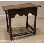 A 17th century Welsh oak side table, the moulded plank top upon tapering cylindrical and block