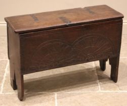A 17th century oak six plank coffer, the moulded top on later hinges over a front panel carved