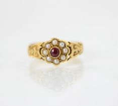 A Victorian 22ct yellow metal split pearl ring, the central round red stone within a surround of