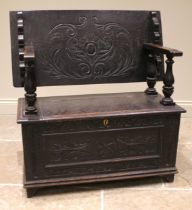 A Victorian carved oak monks bench, in the 17th century style, the sliding back rest upon four