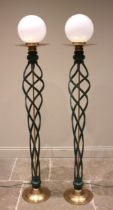 A pair of contemporary wrought iron open twist floor lamps, each with a spherical opaque glass shade