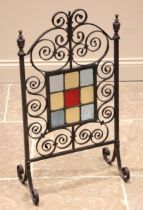 An Arts & Crafts style firescreen, early 20th century, the central leaded coloured glass panel set