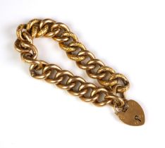 A yellow metal bracelet, the hollow curb links with engraved detail, suspending a heart shaped padl
