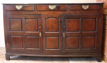 An 18th century oak dresser base, the twin plank moulded top over three lip moulded frieze drawers