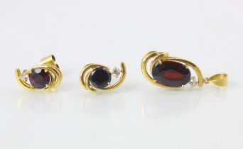 A suite of red stone jewellery, comprising ring, earrings, and pendant, the oval cut red stone set