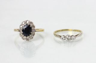 An early 20th century diamond set three stone ring, the mixed cut diamonds in white metal illusion