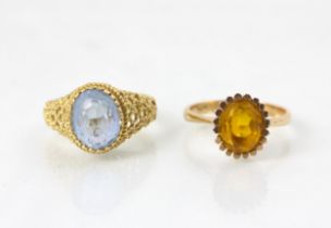 A paste set dress ring, the oval cut blue stone leading to openwork shoulders and plain polished