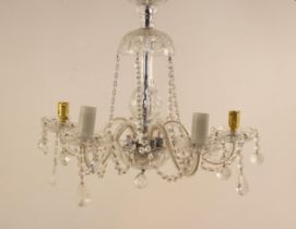 A cut glass chandelier, 20th century, the domed top leading to five scrolling arms, suspending cut