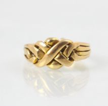 A yellow metal ‘puzzle’ ring, the stylised knot front comprised of four strands, stamped ‘21c’