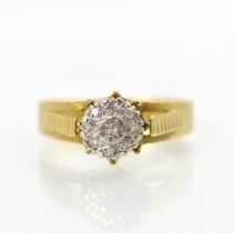 An 18ct yellow gold diamond cluster ring, the round cut diamonds within white metal illusion setting