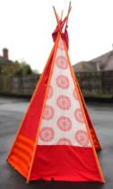 A folding teepee, the five tubular alloy supports covered in vibrant red and orange fabric, pole