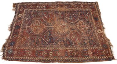 A Caucasian hand knotted wool rug, in red, blue and ivory colourways, the central field with three