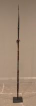 An iron spear stand, with twin loops supporting an iron barbed and bound hardwood spear, 196cm high