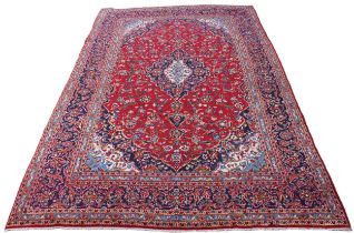 A large red ground Persian Kashan carpet, in red, blue, green and ivory colourways, the central