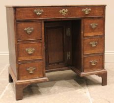 A George III oak kneehole desk, the rectangular moulded top over a single frieze drawer and two