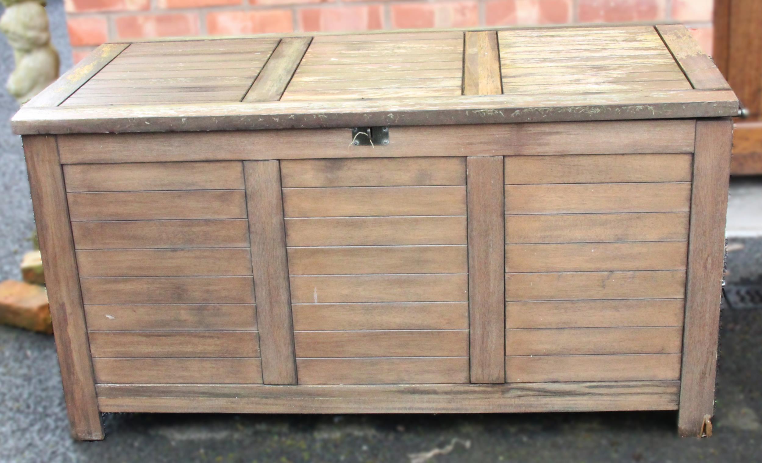 An outdoor teak storage chest, of slatted form with a hinged cover and fitted side handles, upon