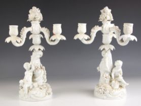 A pair of German porcelain white glazed figural candelabra, 19th century, each of three branch