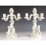 A pair of German porcelain white glazed figural candelabra, 19th century, each of three branch