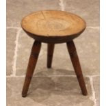 A provincial Welsh ash and sycamore tripod stool, the gently dished circular seat upon three