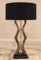 An antelope antler table lamp, the two symmetrically twisted antlers enclosing a central light