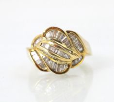 A gold coloured and diamond set dress ring, the raised head with channel set fancy cut diamonds,