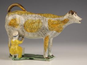 An English pottery pearlware cow creamer, circa 1800 (Yorkshire), with sponged decoration in yellow,