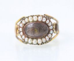 A 19th century style seed pearl mourning ring, the oval glazed aperture with surround of seed