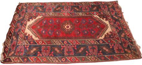 A Turkish hand knotted wool rug, in red, blue and ivory colourways, the central lozenge shaped field