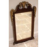 A George II walnut, giltwood and gesso pier mirror, the acanthus crest enclosed by a twin swan