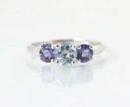 A three stone untested amethyst and blue topaz ring, the central round cut untested blue topaz