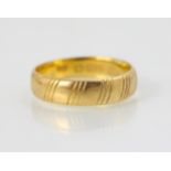 An engraved 22ct yellow gold wedding band, with striped decoration, stamped 'SH' Birmingham,