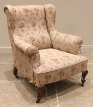 A George III style wingback armchair, late 19th/early 20th century, the padded wing backs and