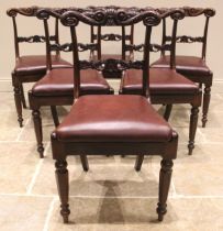 A set of seven George IV rosewood dining chairs, each with a carved scrolled crest rail over a