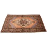 A full pile fine hand woven Iranian rug, with a traditional medallion design, upon a pink ground,