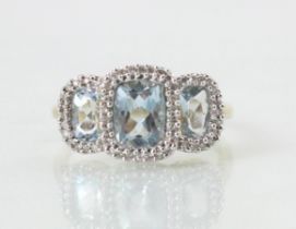 An Edwardian style untested blue topaz triple cluster ring, the cushion cut untested topaz within