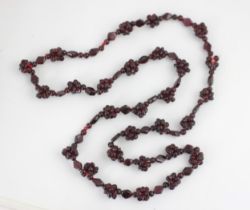 A strand of untested garnet beads, the non-uniform polished beads with twenty-seven clusters of