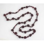 A strand of untested garnet beads, the non-uniform polished beads with twenty-seven clusters of
