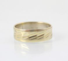 A white metal wedding band, the band with engraved detail, stamped '750' 4.3gms (at fault)