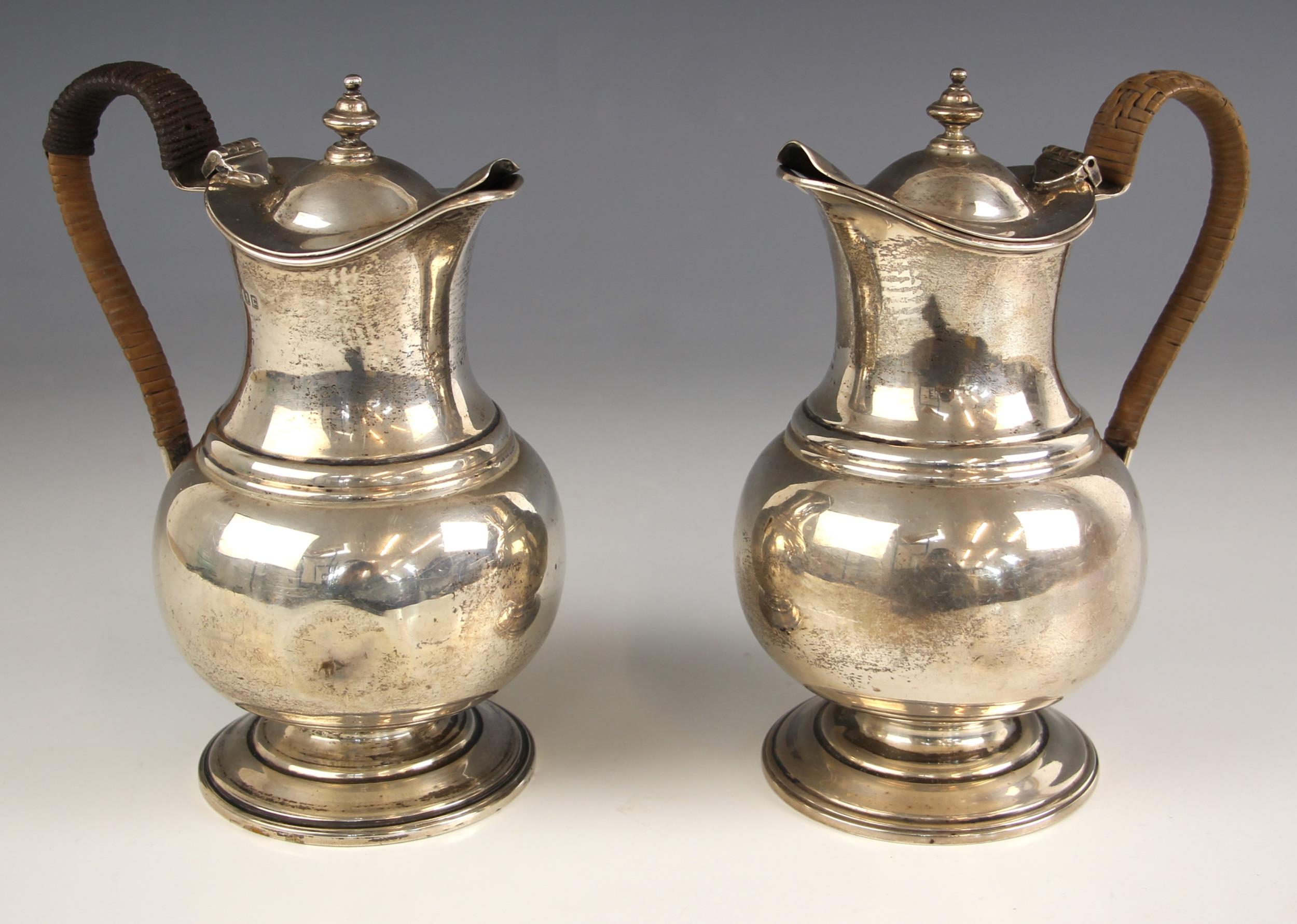 A pair of George V silver coffee pots, Pairpoint Brothers, London 1918, the wicker wrapped handle