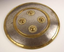 An Indo-Persian circular shield or dhal, 19th century, the convex steel body with brass mounted