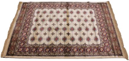 An ivory ground Kashmir traditional Bokhara rug, in red, blue and ivory colourways, the central