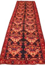 An Iranian village carpet, in rich red and blue colourways, the unique all over design, with two