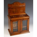 An Edwardian oak smokers compendium, modelled as a dresser with glazed doors and open pipe rack, two