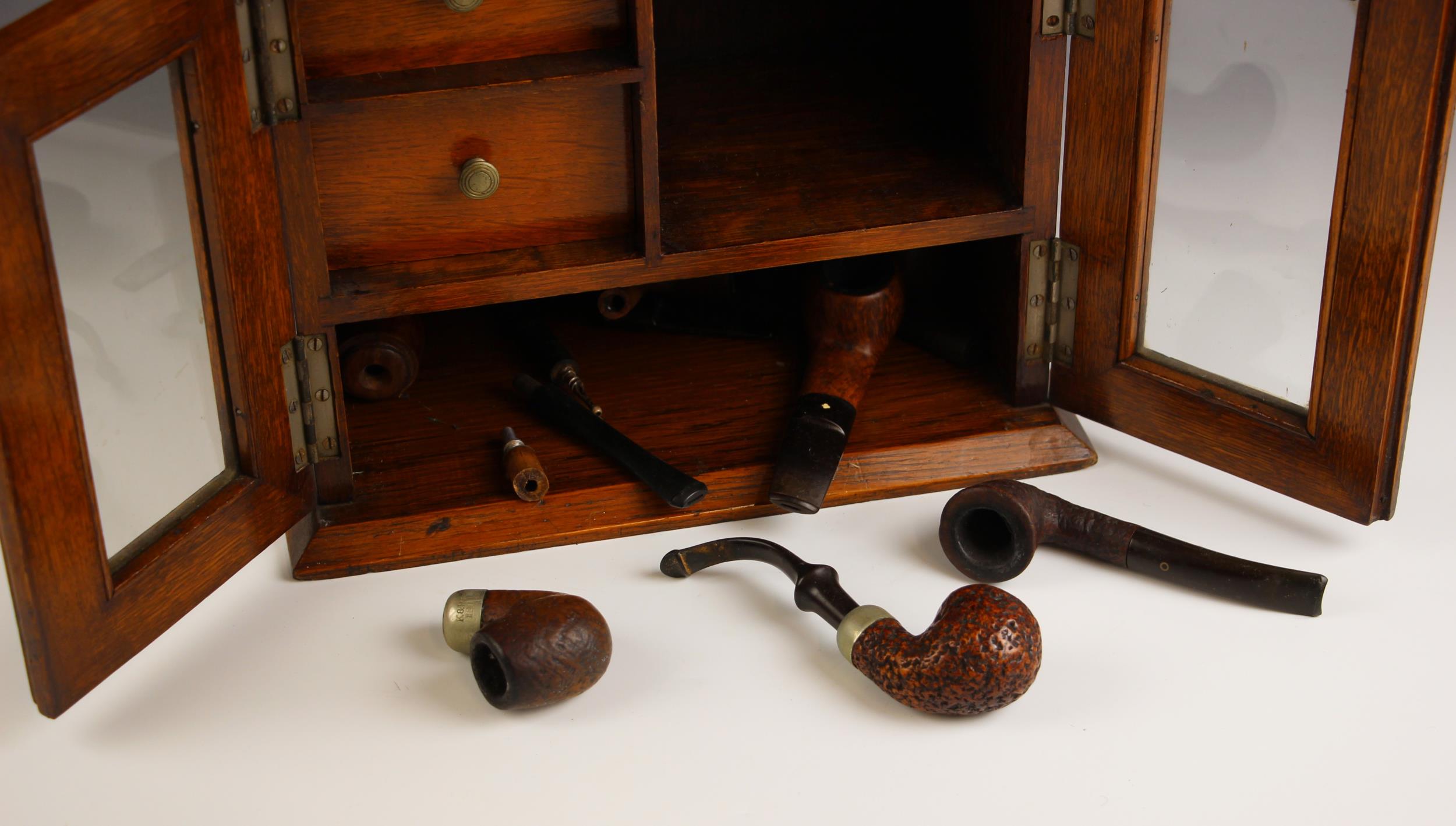 An Edwardian oak smokers compendium, modelled as a dresser with glazed doors and open pipe rack, two - Image 2 of 2