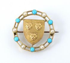 A gold coloured brooch, the circular brooch with paste pearls and turquoise coloured stones, with